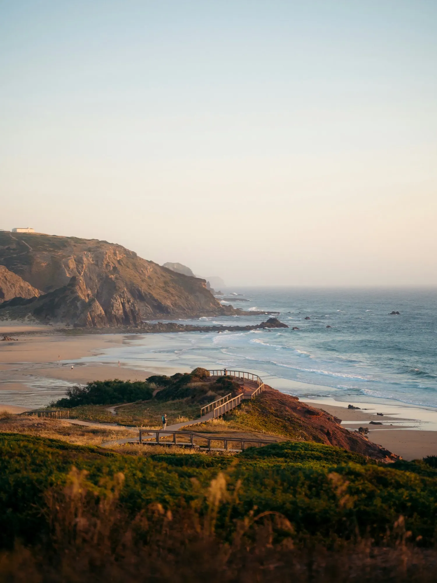 The Atlantic coast of Portugal in evening light, cliffs and a wooden path