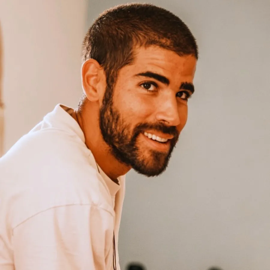 David Codesido smiling, in a white shirt, warm light